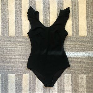 Black bodysuit with ruffle detail on shoulder